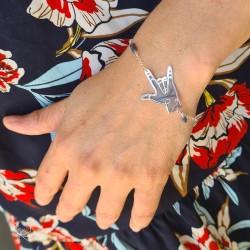 Photo d'une main et d'un poignet, portant un bracelet en argent formant un signe de Langues des signes, voulant dire "Je t'aime"