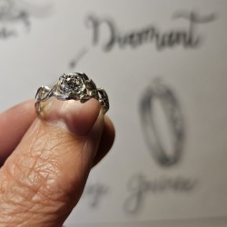 Bague portée au doigt devant les croquis préparatoires de sa création
